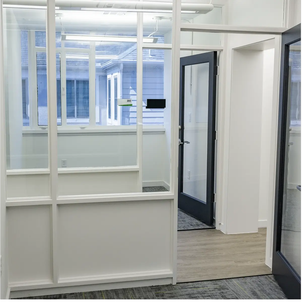 Hallway in Houston, TX featuring glass doors and a solid door at the end in Houston, TX