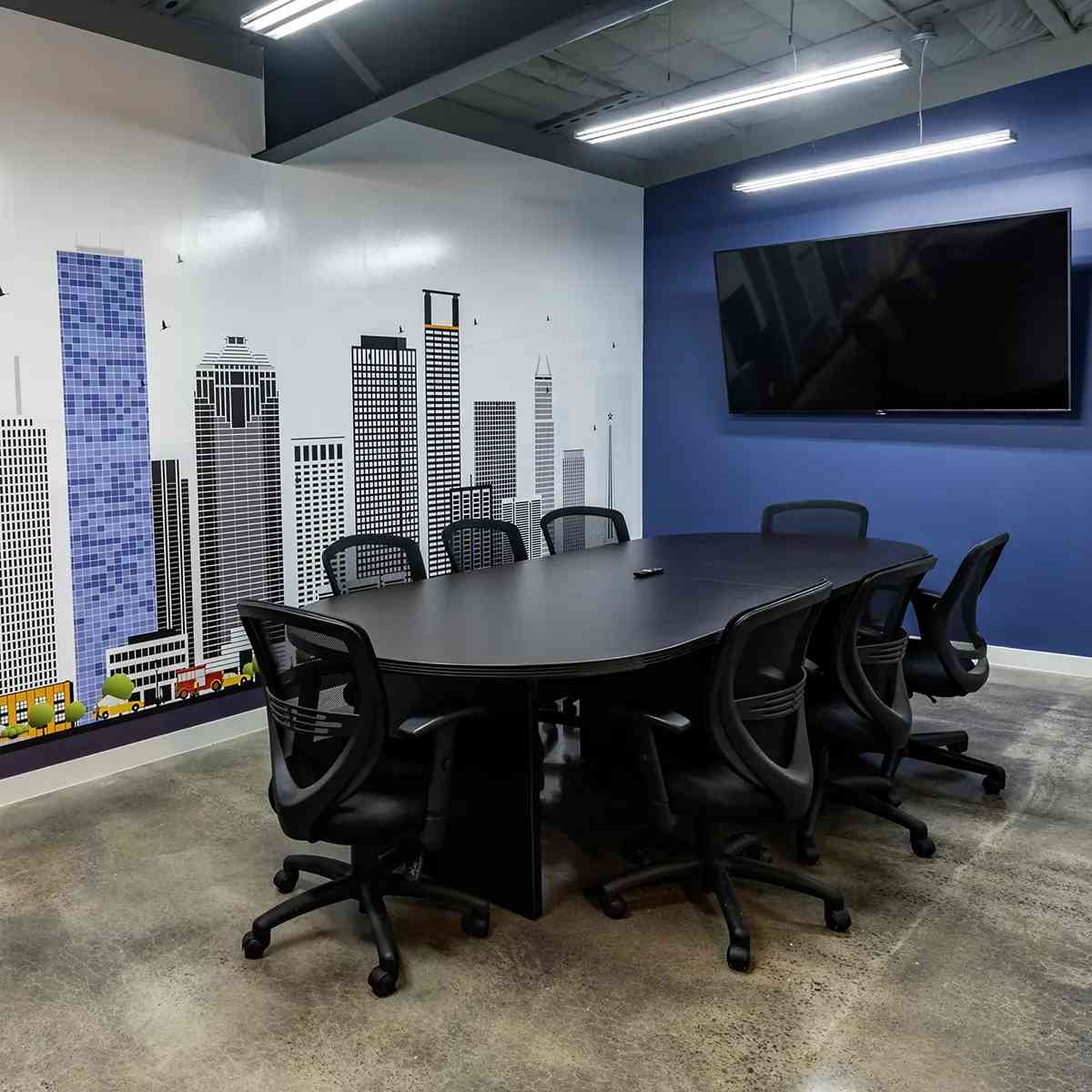 A conference room featuring a large mural wall at Heights Waterworks in Houston, TX