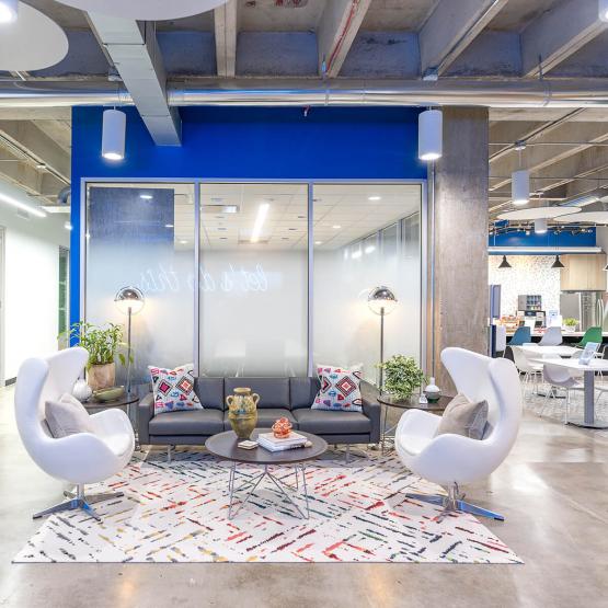 Seating area with tables, sofa, chairs & rug in West Heights office location from Urban Office
