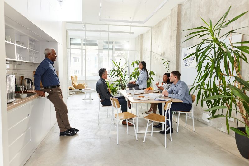 Coworkers in the break room smiling by Urban Office