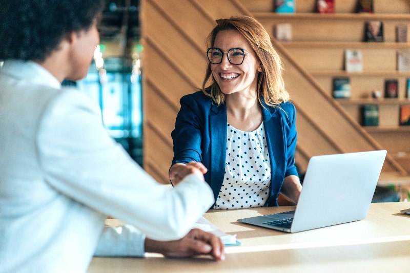 Two Women Shaking Hands at a Desk in Texas