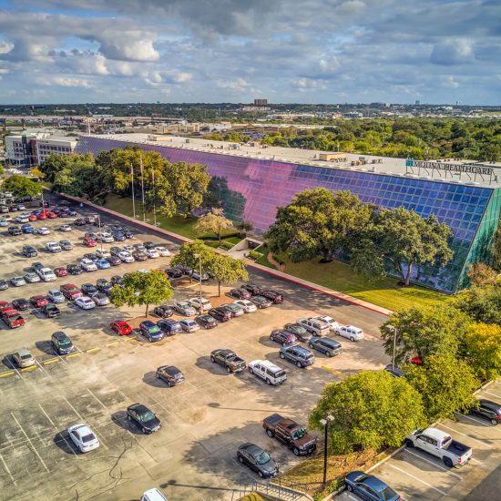 An Aerial View of a Parking Lot with a Large Building in the Background in San Antonio, TX