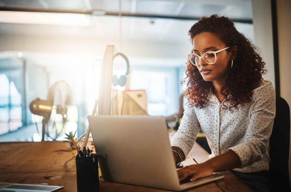 A Woman Working at a Dedicated Desk in a Coworking Space in Houston, TX