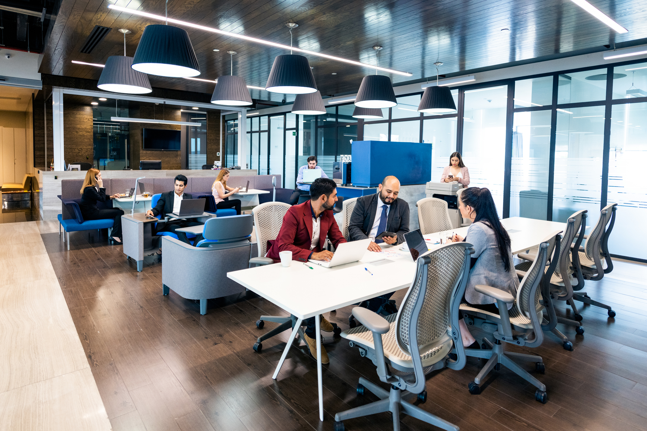 Team collaborating around an interactive touchscreen display and laptop during a digital workspace planning session.