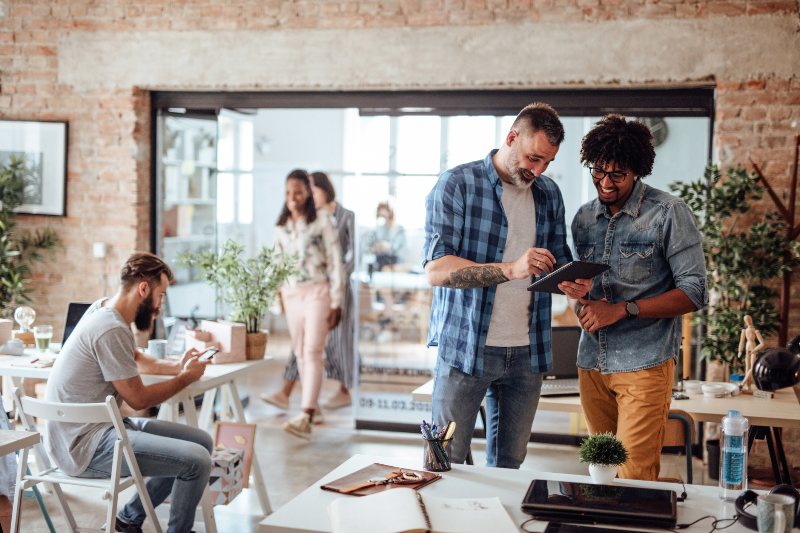 Men looking at tablet together in office by Urban Office in Houston and San Antonio