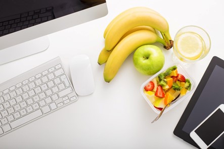 A Workplace displaying a Laptop, Keyboard, & Banana Highlighting Snacks in-office in Houston, TX