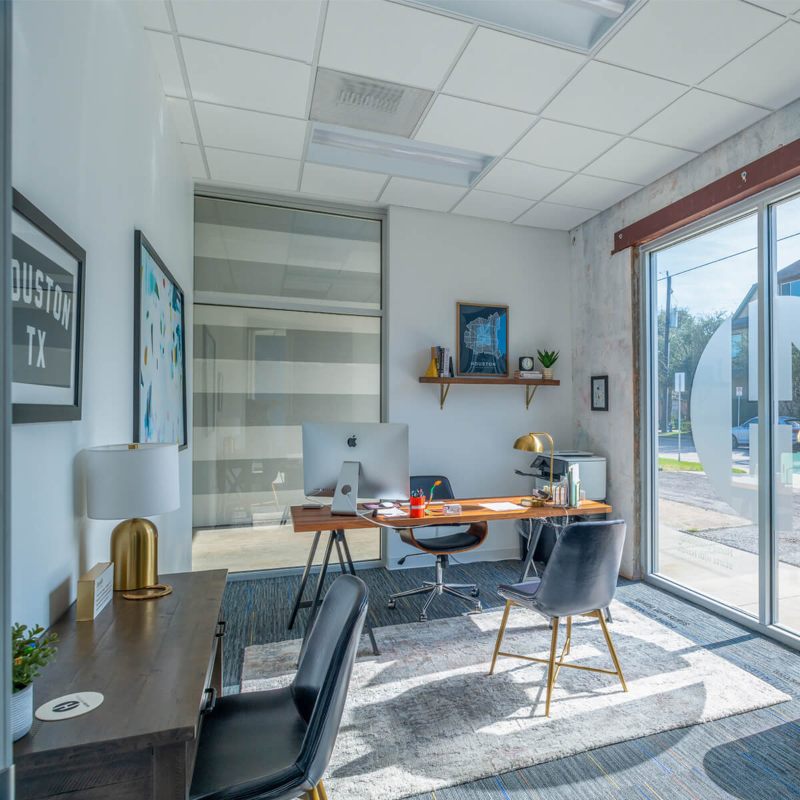 Desk Positioned Near Glass Doors in the Spring Branch Village Office in Houston, TX