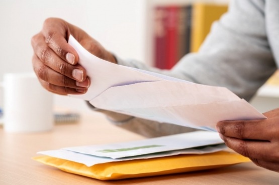 An entrepreneur opening a business mail at a coworking space in San Antonio, Texas