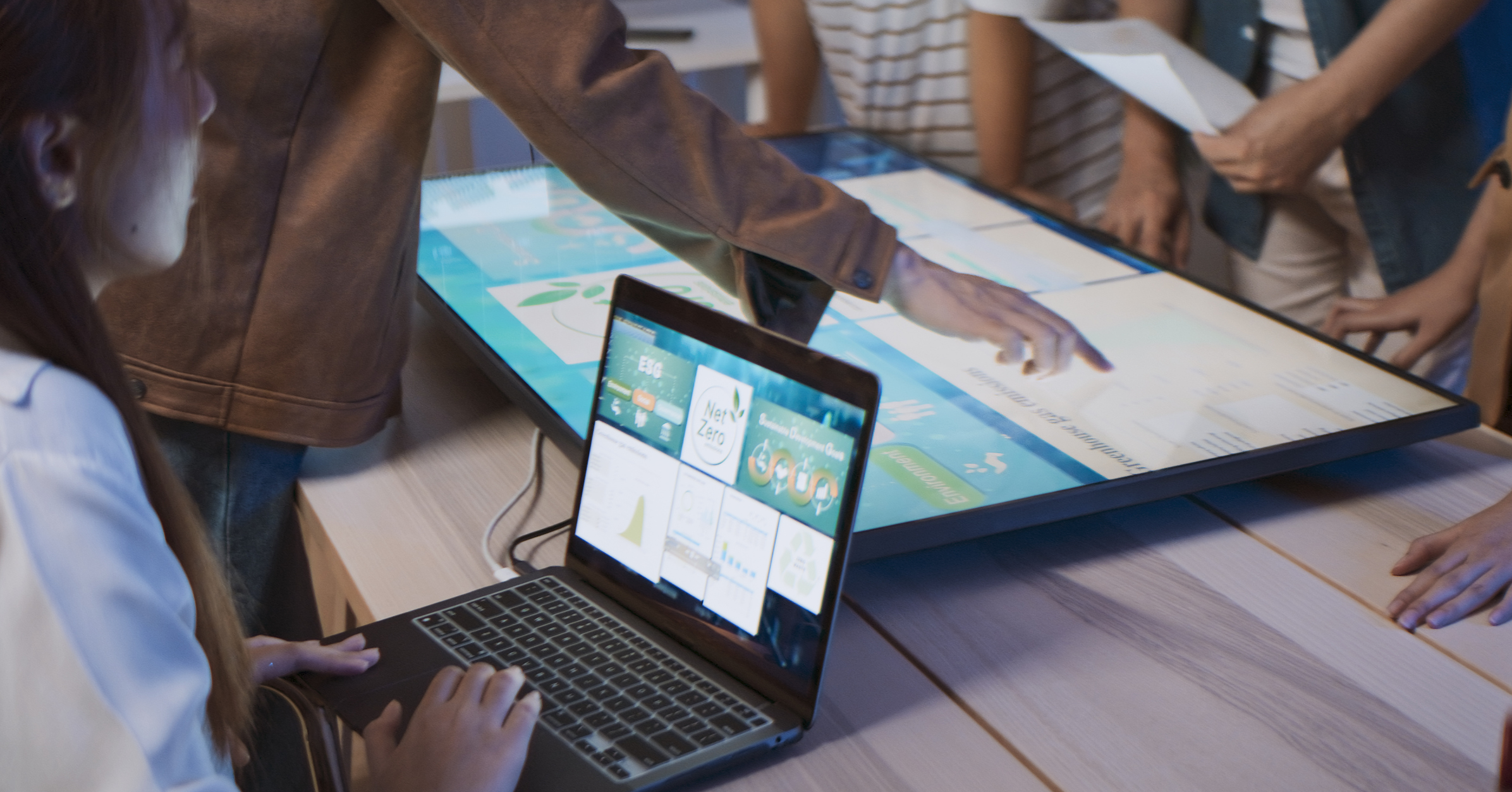Employees working collaboratively in a modern openu2011plan office with shared desks, meeting areas, and laptops.