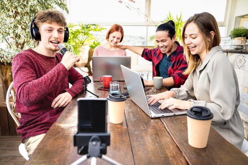 A group of influencers around laptops at a table by Urban Office