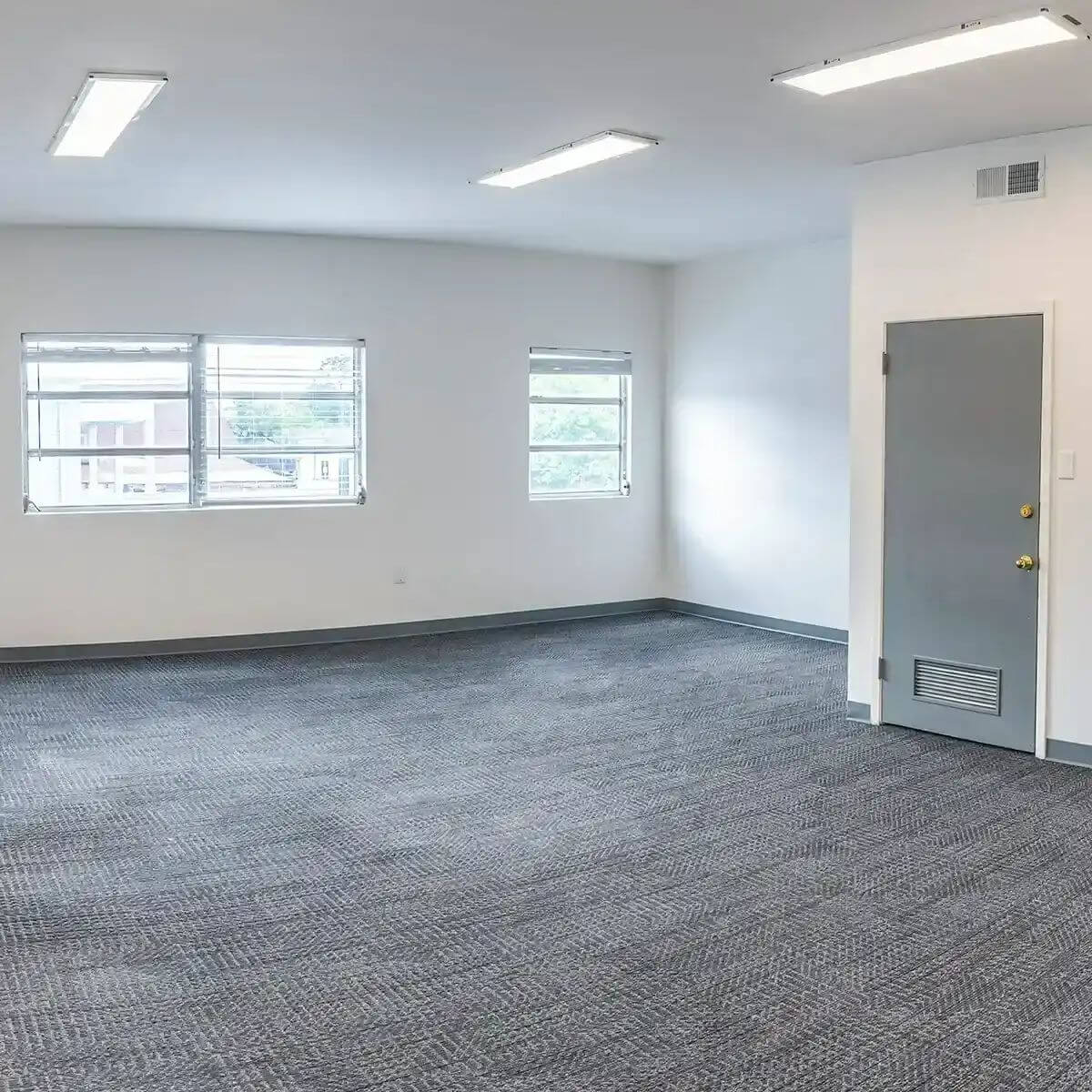 Empty office space at Heights Commons featuring gray carpeting and white walls in Texas