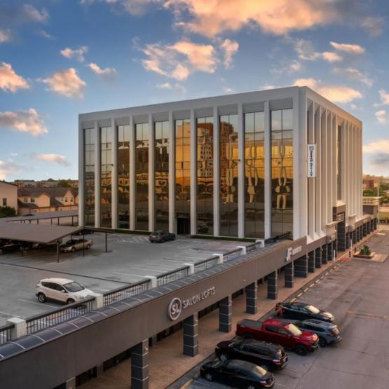 A Large Building's Exterior with Several Cars Parked in Front in Houston, TX