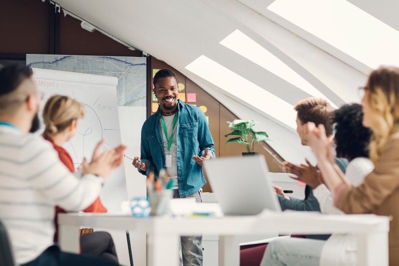 A man presents to an audience seated in a conference room in Houston, TX
